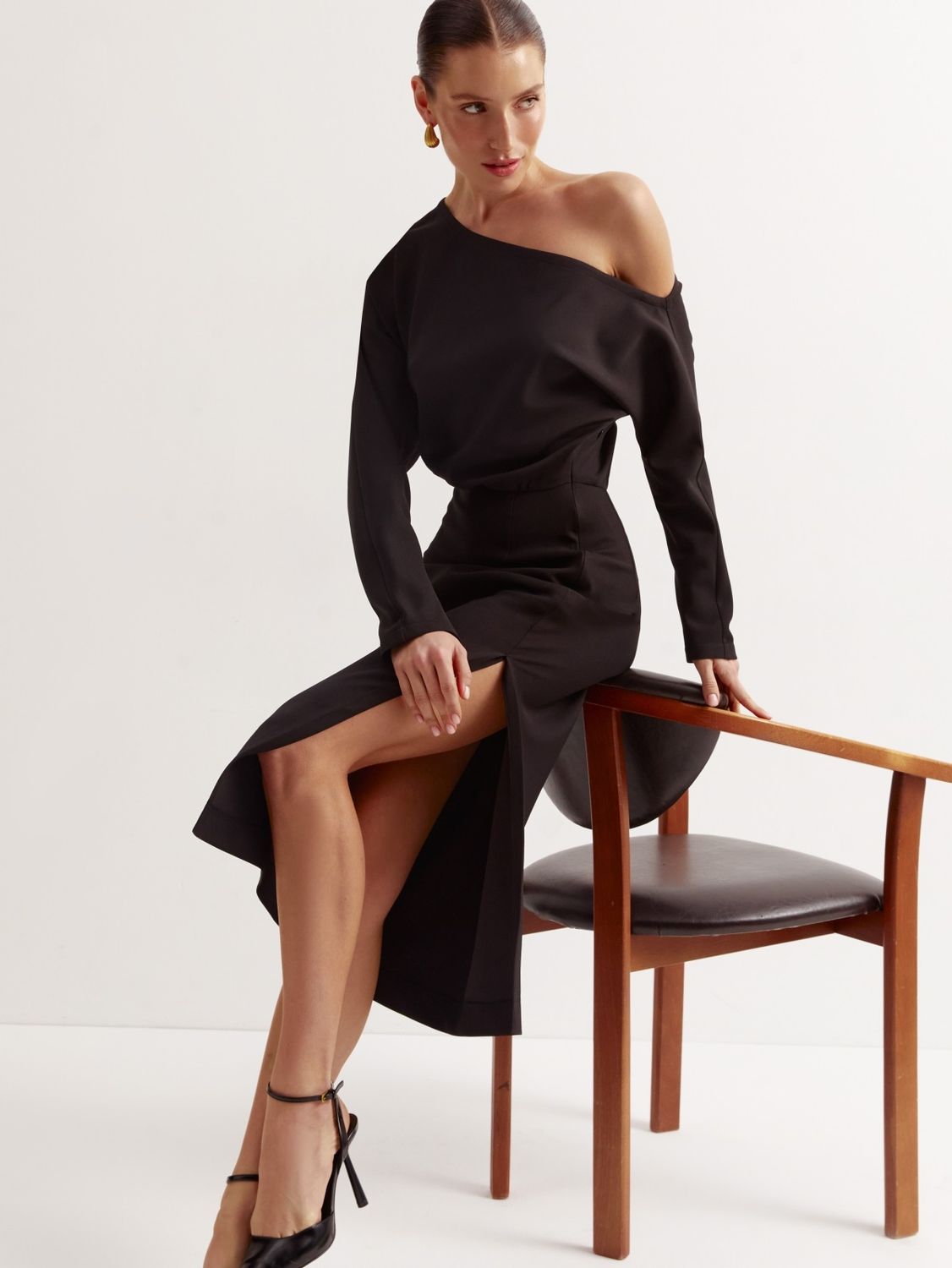 Черное вечернее платье с разрезом на ноге - фото